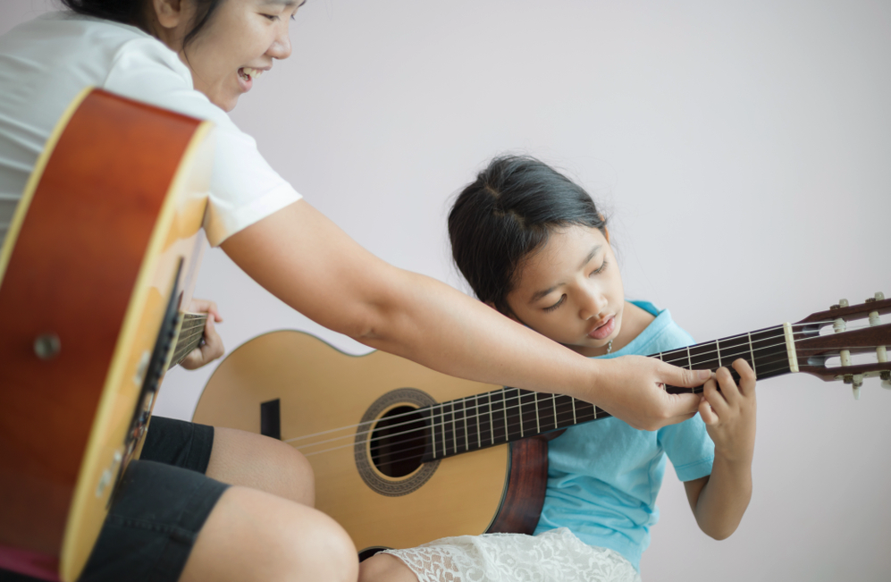A child taking a guitar lesson
